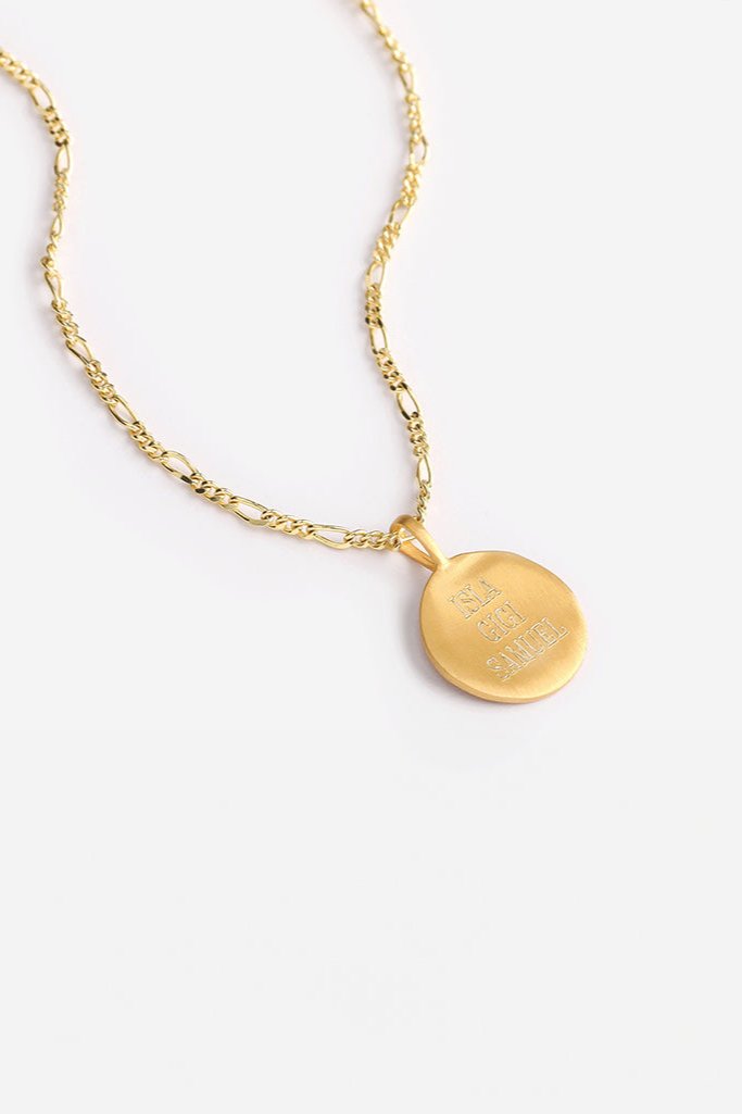 Engraved gold signature necklace with three names, displayed on Figaro chain for a bold, meaningful keepsake.