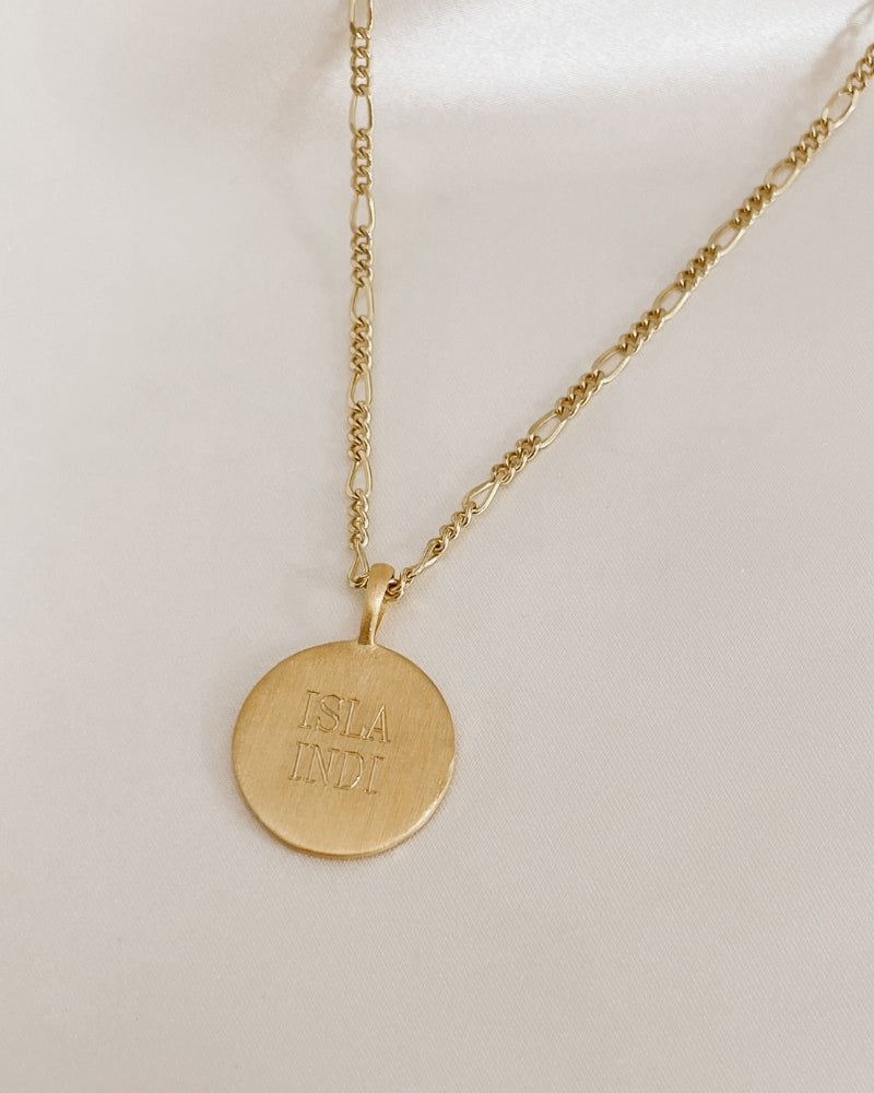 A close up of a Signature necklace with two names engraved on the front of it.