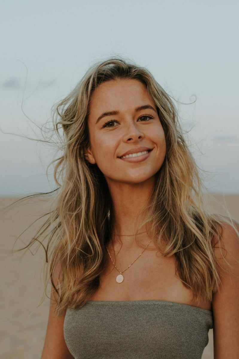 Model wearing engraved rose gold pendant necklace as a single statement piece