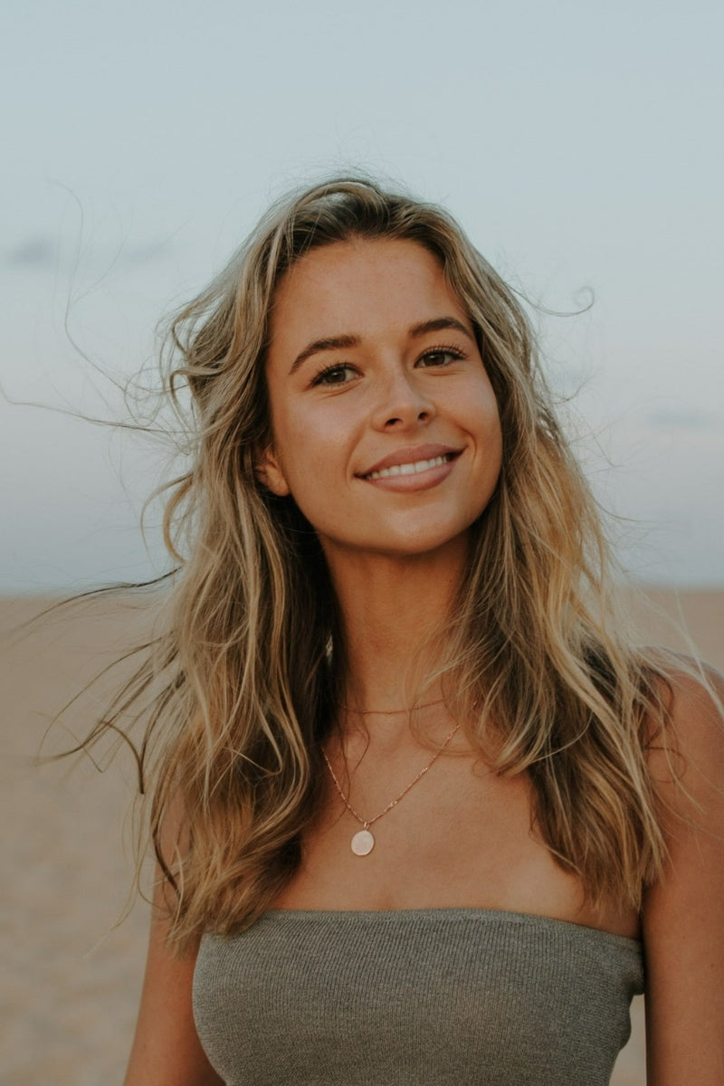 Model wearing engraved rose gold pendant necklace as a single statement piece