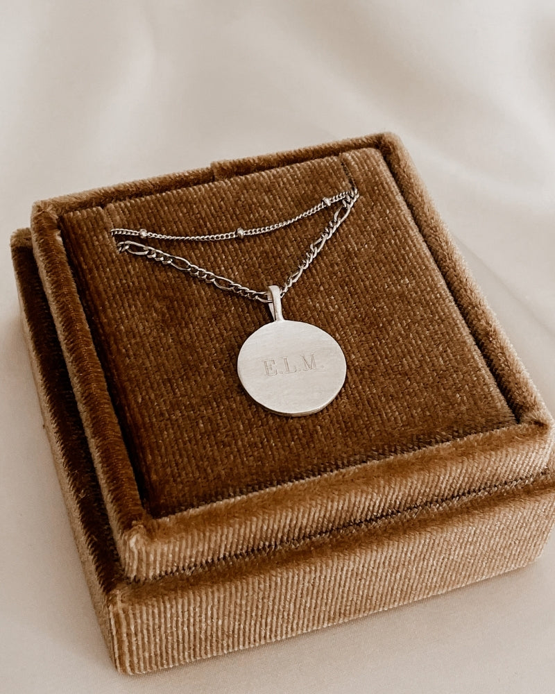 Silver personalised pendant necklace with engraved lettering on velvet box.