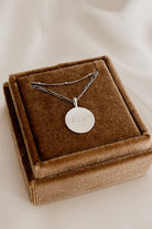 Silver personalised pendant necklace with engraved lettering on velvet box.
