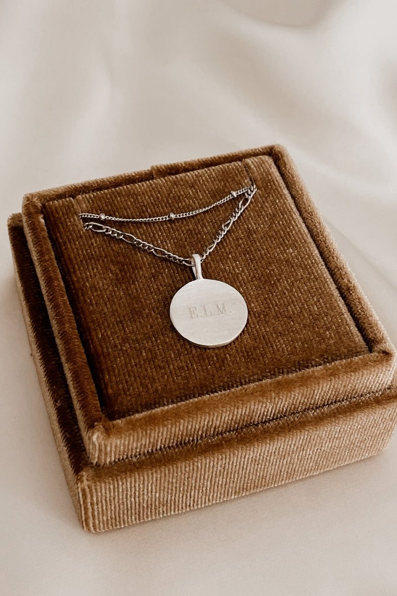 Silver personalised pendant necklace with engraved lettering on velvet box.