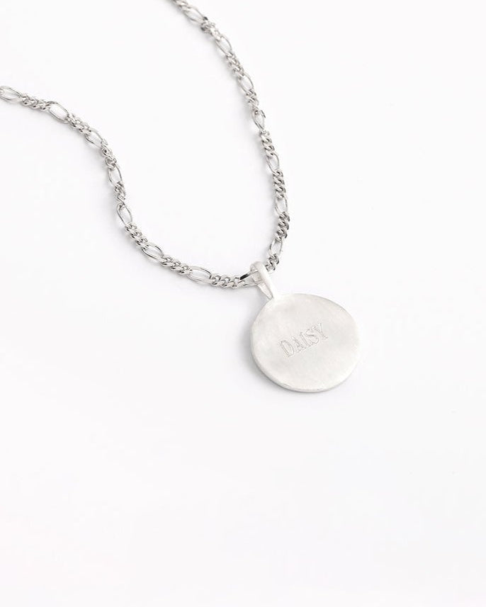 Engraved silver round pendant necklace with figaro-style chain.