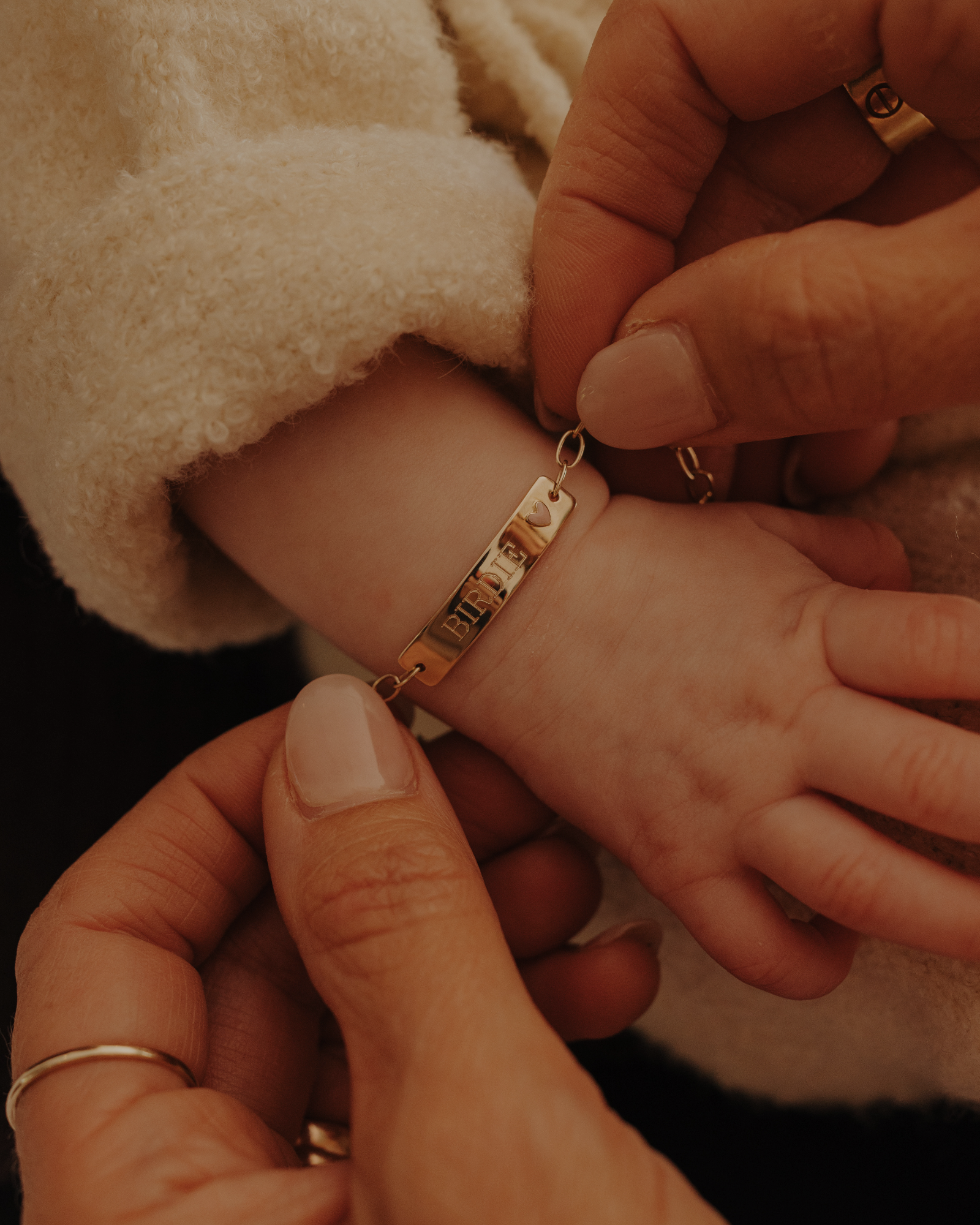 Close-up of baby hand wearing engraved 9ct solid gold Pink Darling Bracelet, a forever keepsake