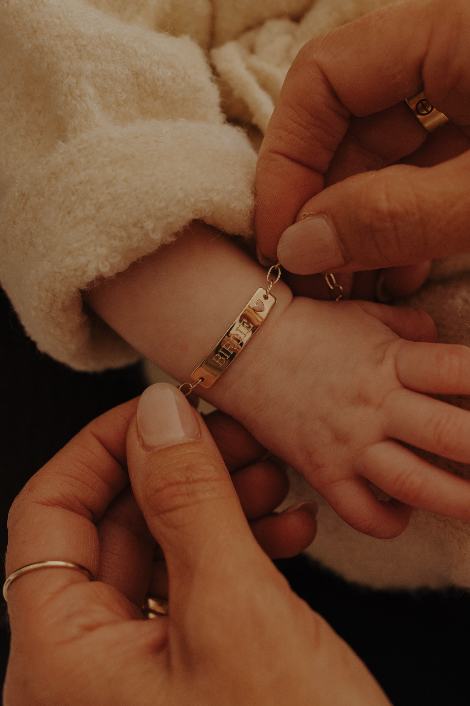 Close-up of baby hand wearing engraved 9ct solid gold Pink Darling Bracelet, a forever keepsake
