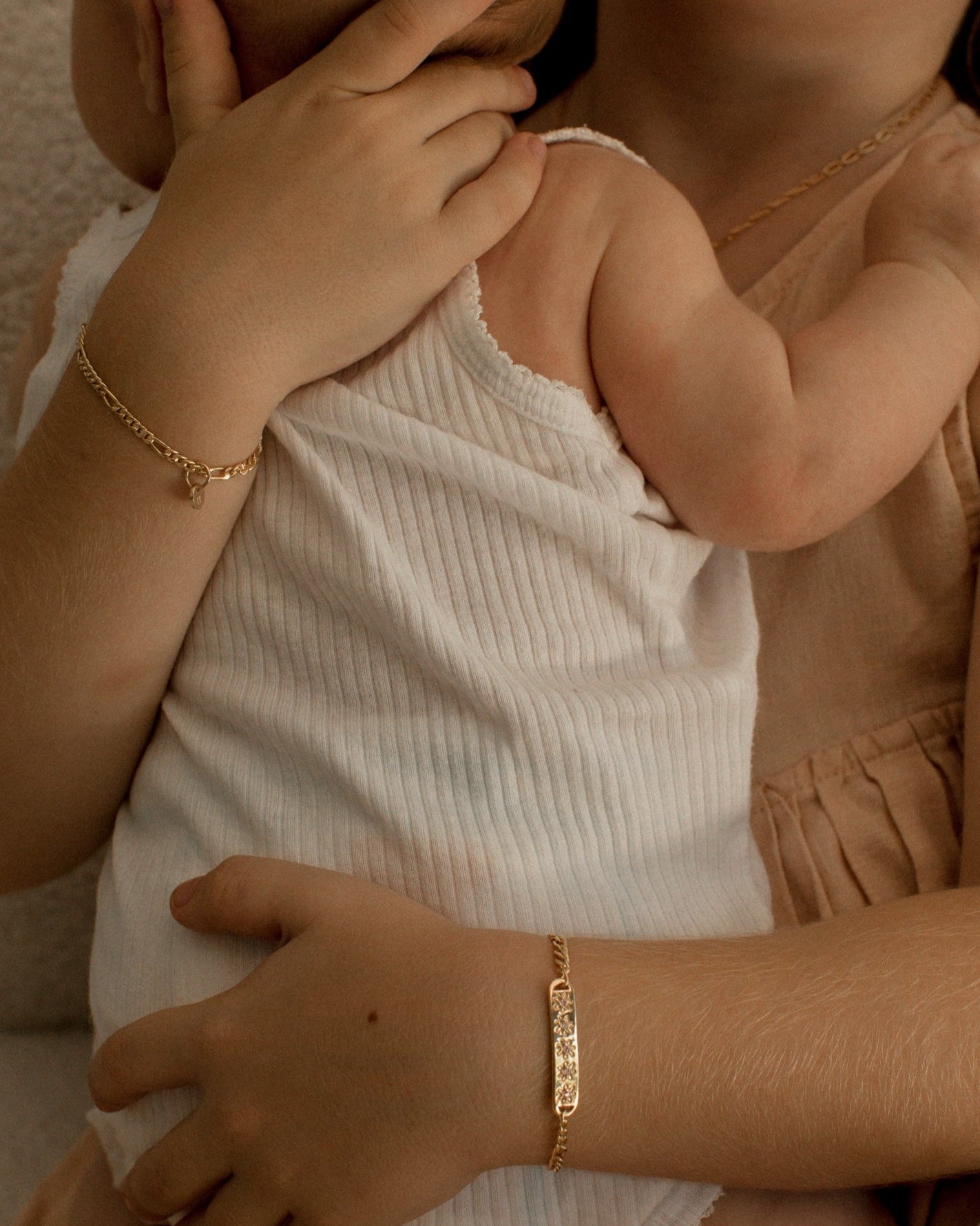 A girl is wearing the child length Daisy Bracelet in Gold Vermeil by Bluebird Jewellery