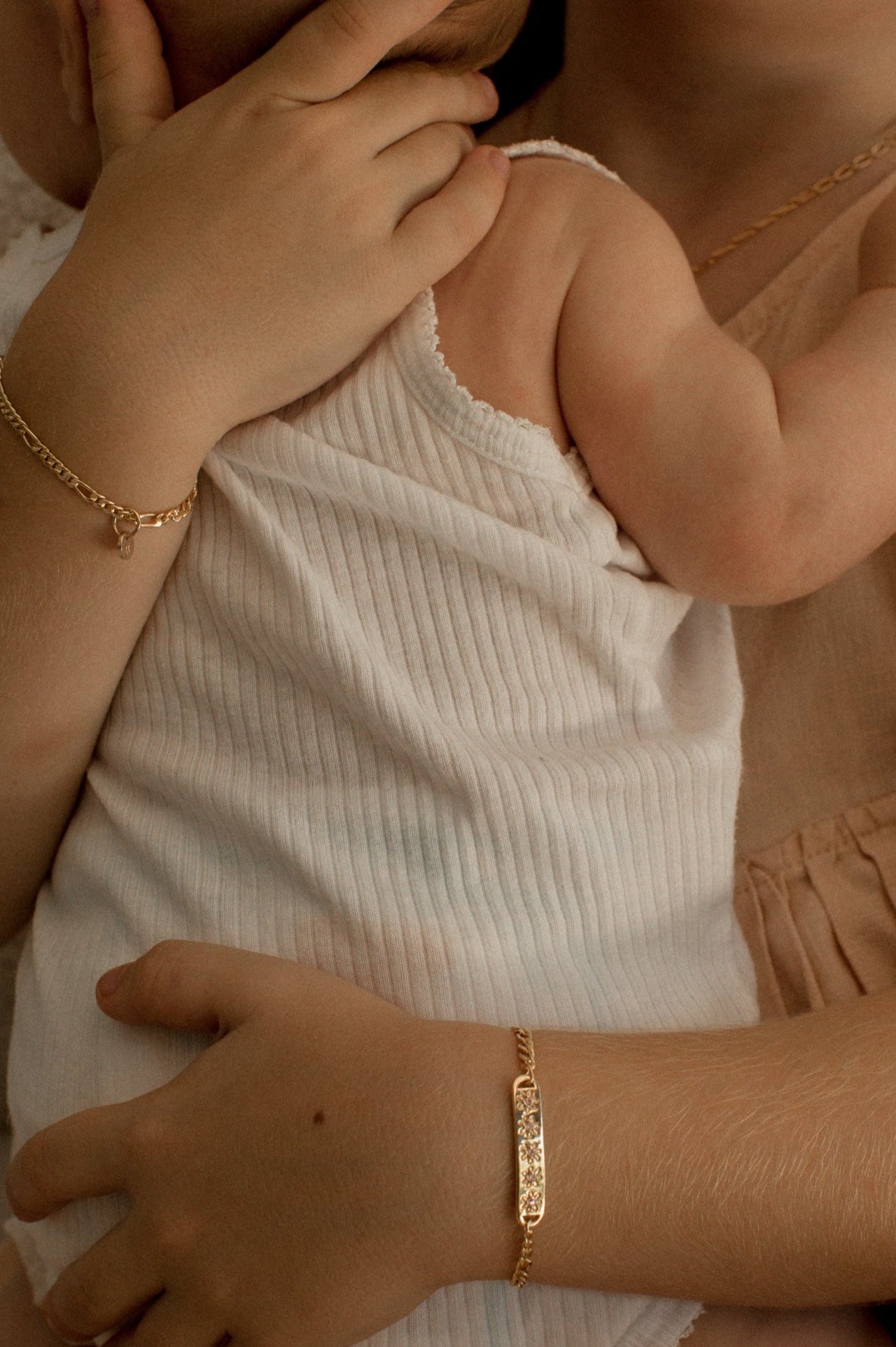 A girl is wearing the child length Daisy Bracelet in Gold Vermeil by Bluebird Jewellery