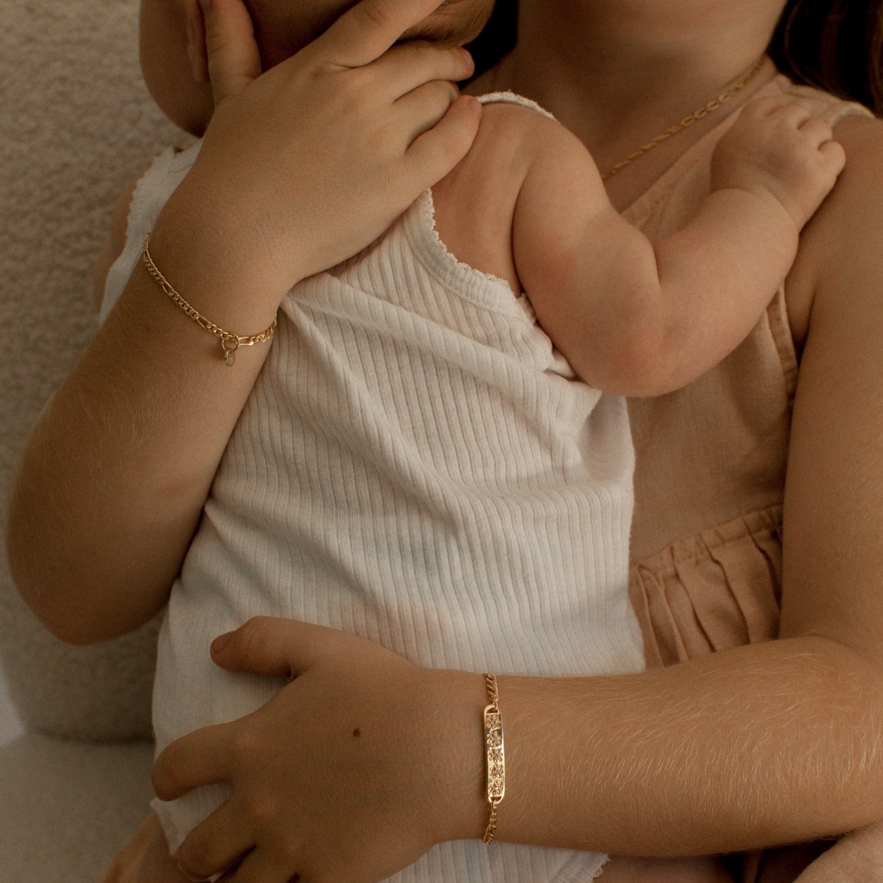 A girl is wearing the child length Daisy Bracelet in Gold Vermeil by Bluebird Jewellery