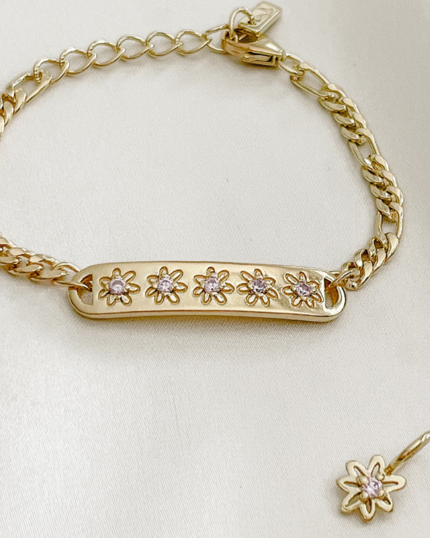 The Daisy Bracelet by Bluebird Jewellery, featuring five hand-drawn daisies with pink cubic zirconia centres, crafted as a feminine and floral fine jewellery piece.