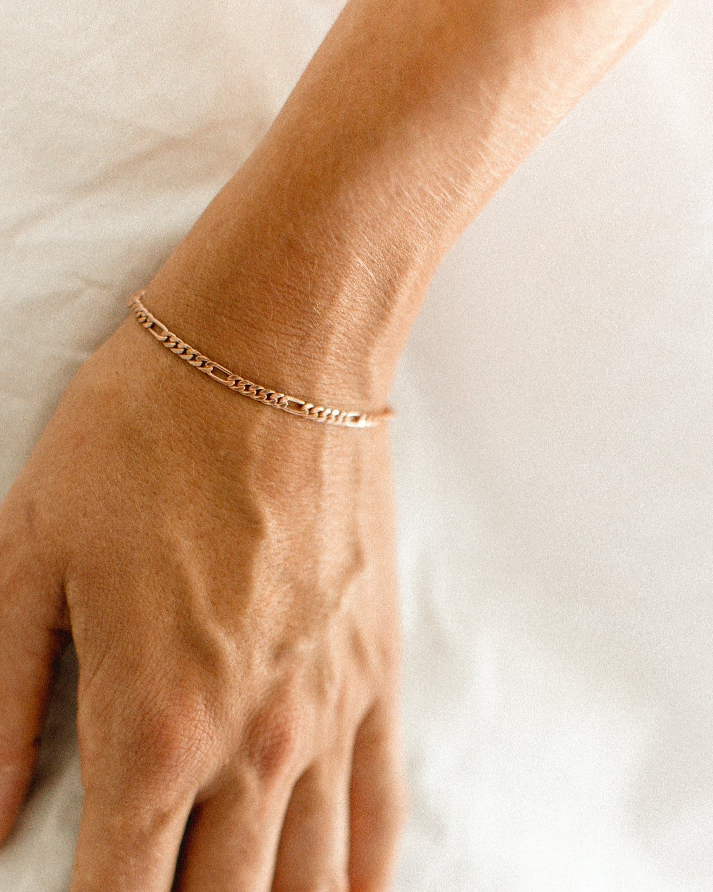 The Bluebird Jewellery Figaro Bracelet, a timeless fine chain design with adjustable sizing, crafted as an elegant everyday piece.