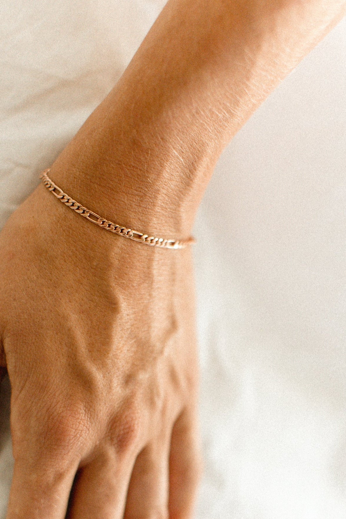 The Bluebird Jewellery Figaro Bracelet, a timeless fine chain design with adjustable sizing, crafted as an elegant everyday piece.