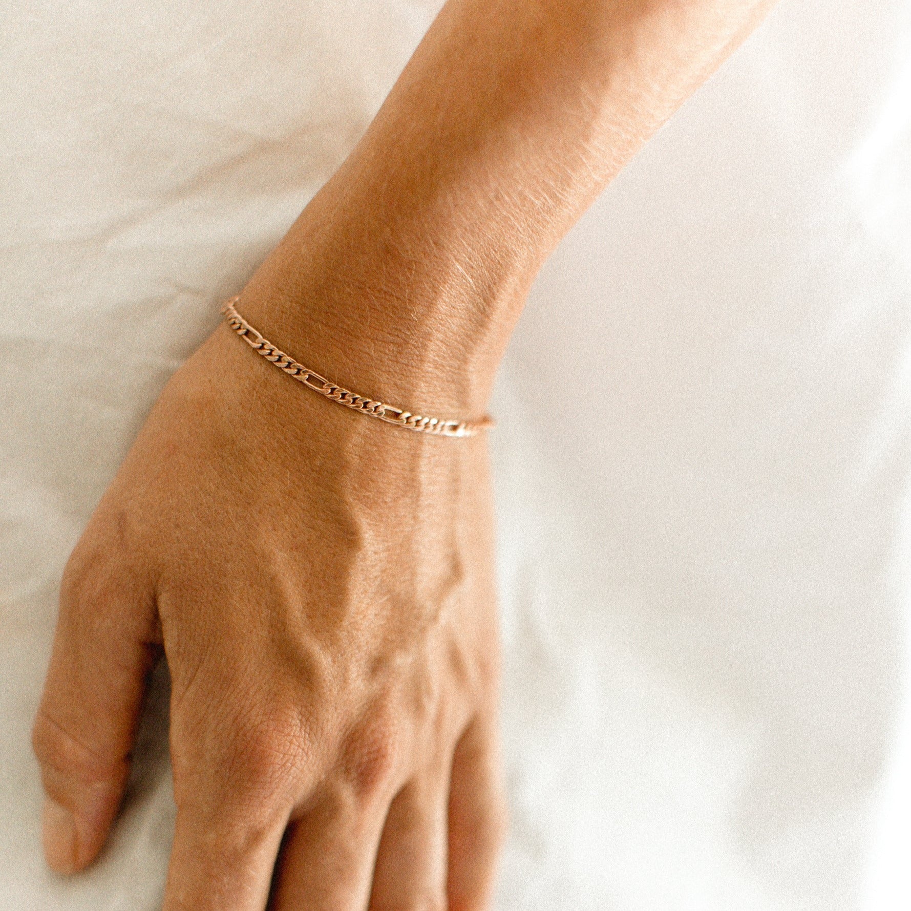 The Bluebird Jewellery Figaro Bracelet, a timeless fine chain design with adjustable sizing, crafted as an elegant everyday piece.