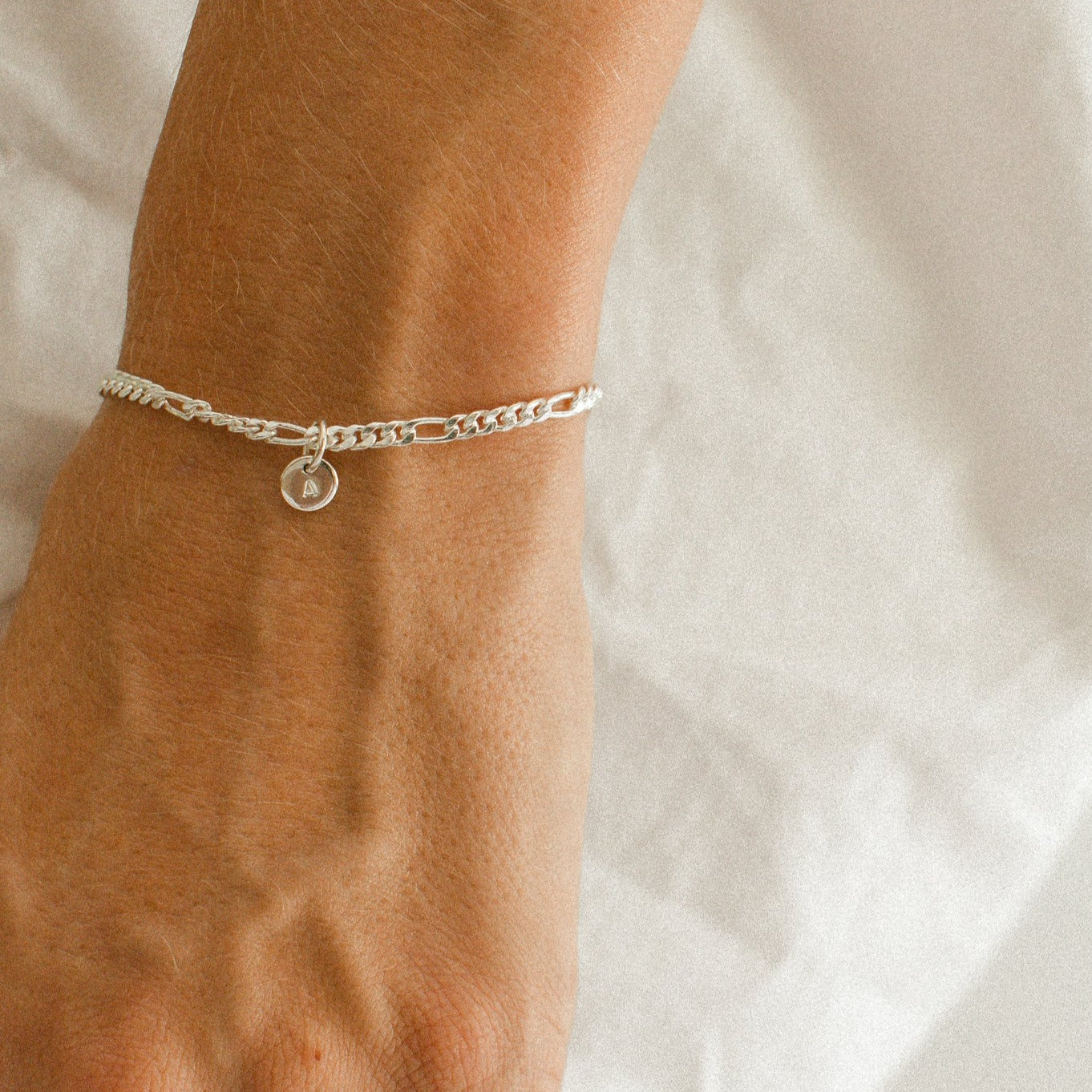 A Figaro Bracelet in adult length worn with one 6mm initial pendant by Bluebird Jewellery