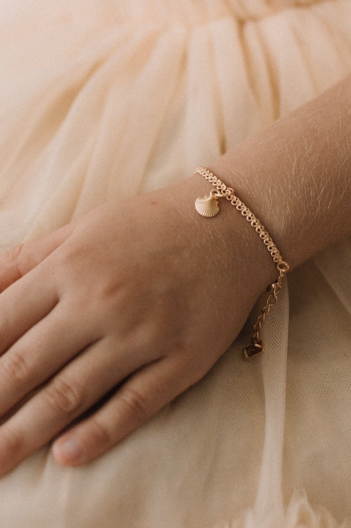 A delicate Lace Chain bracelet with a mermaid shell charm, designed as elegant fine jewellery by Bluebird Jewellery