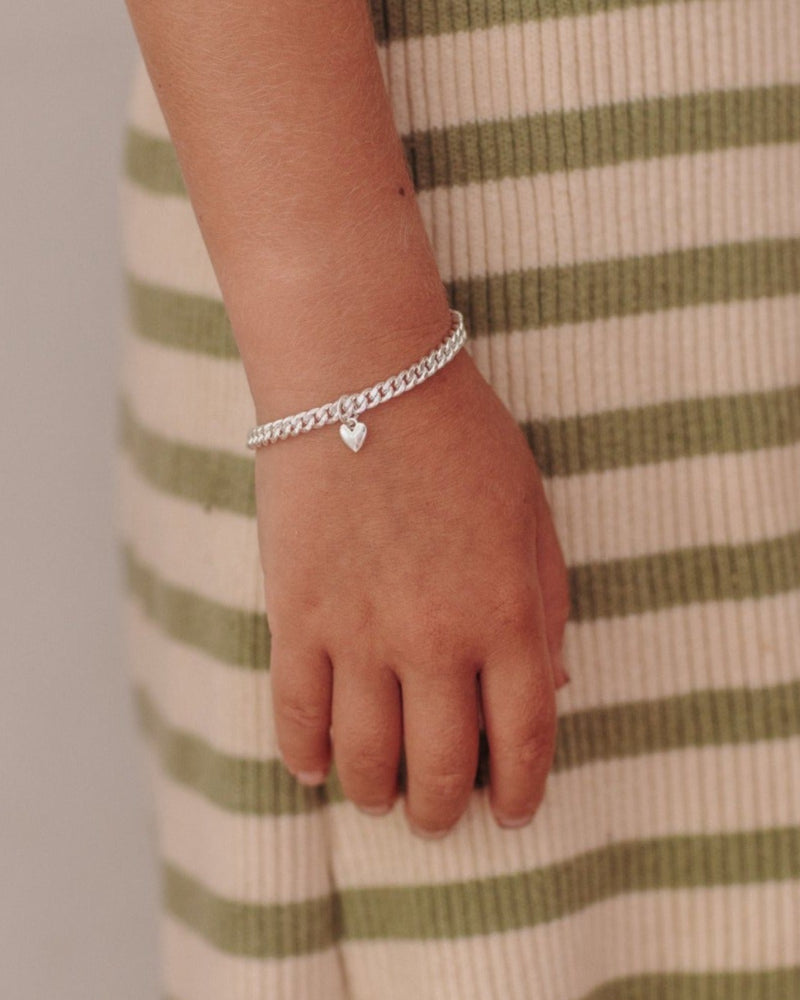 sterling silver cuban link bracelet with a mini sweetheart pendant in sterling silver sits effortlessly on child's wrist by Bluebird Jewellery
