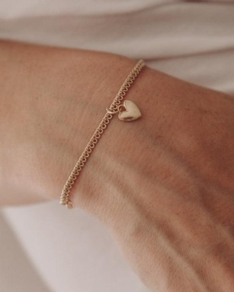 A woman wearing a Sweetheart Lace Chain Bracelet with a regular-sized Sweetheart pendant, crafted as an elegant everyday fine jewellery piece by Bluebird Co