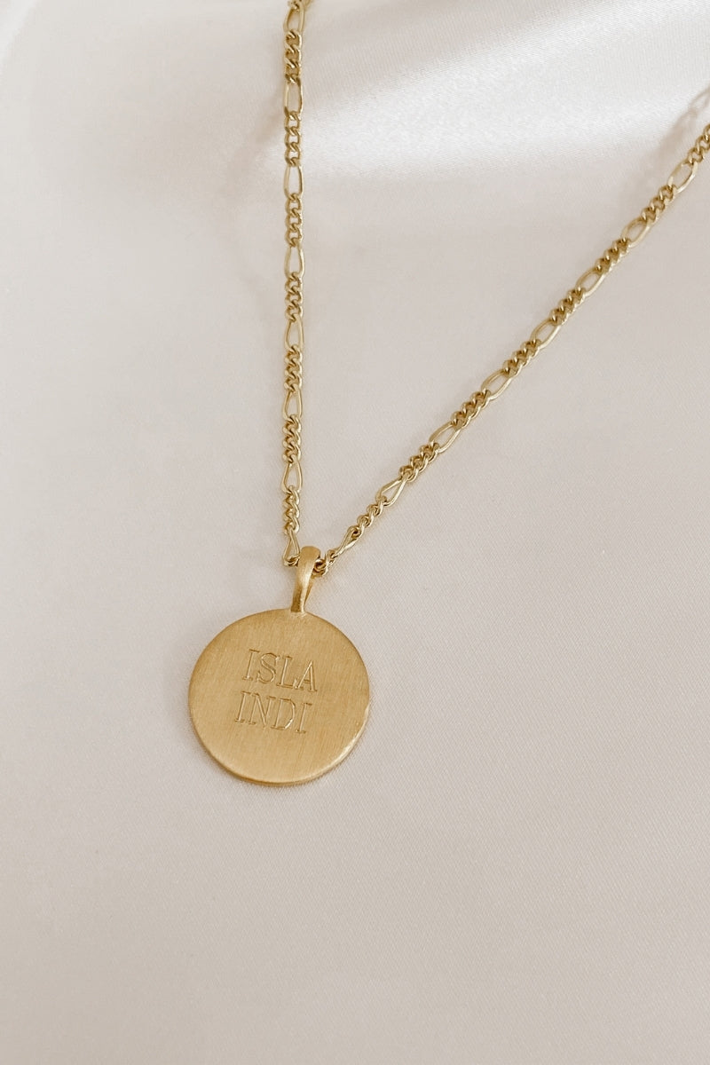 A close up of a Signature necklace with two names engraved on the front of it.