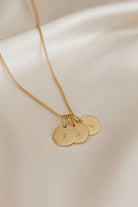 A keeping it personal necklace with three personalised initial pendants on a gold plated fine curb chain.