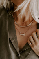 The Signature Statement necklace is layered with the Signature Bar Necklace.