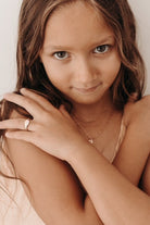 A girl wearing her solid 9ct rose gold signet ring.