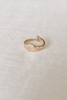 Solid 9ct Gold Signet ring sitting on white linen.  The image shgows the adjustable sides on the child sized ring.