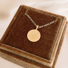 A Signature Necklace with personalised names of three children engraved on the front of it is placed inside a velvet gift box.