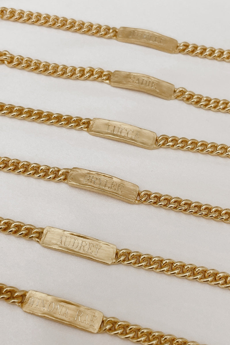 A row of Baby Sized Signature Barcelets all engraved with a name on the front of them.