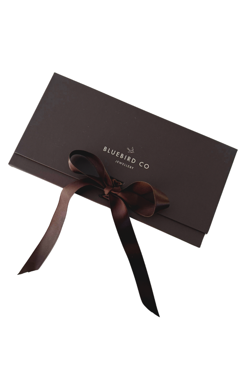 A detailed image of a Bluebird Co chocolate brown gift box with ribbon bow, an elegant presentation box for Bluebird Jewellery gifting.