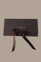 A detailed image of a Bluebird Co chocolate brown gift box with ribbon bow, an elegant presentation box for Bluebird Jewellery gifting.