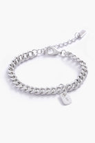 A fine silver bracelet with a rectangular initial pendant, photographed up close to highlight its personalised details and craftsmanship.