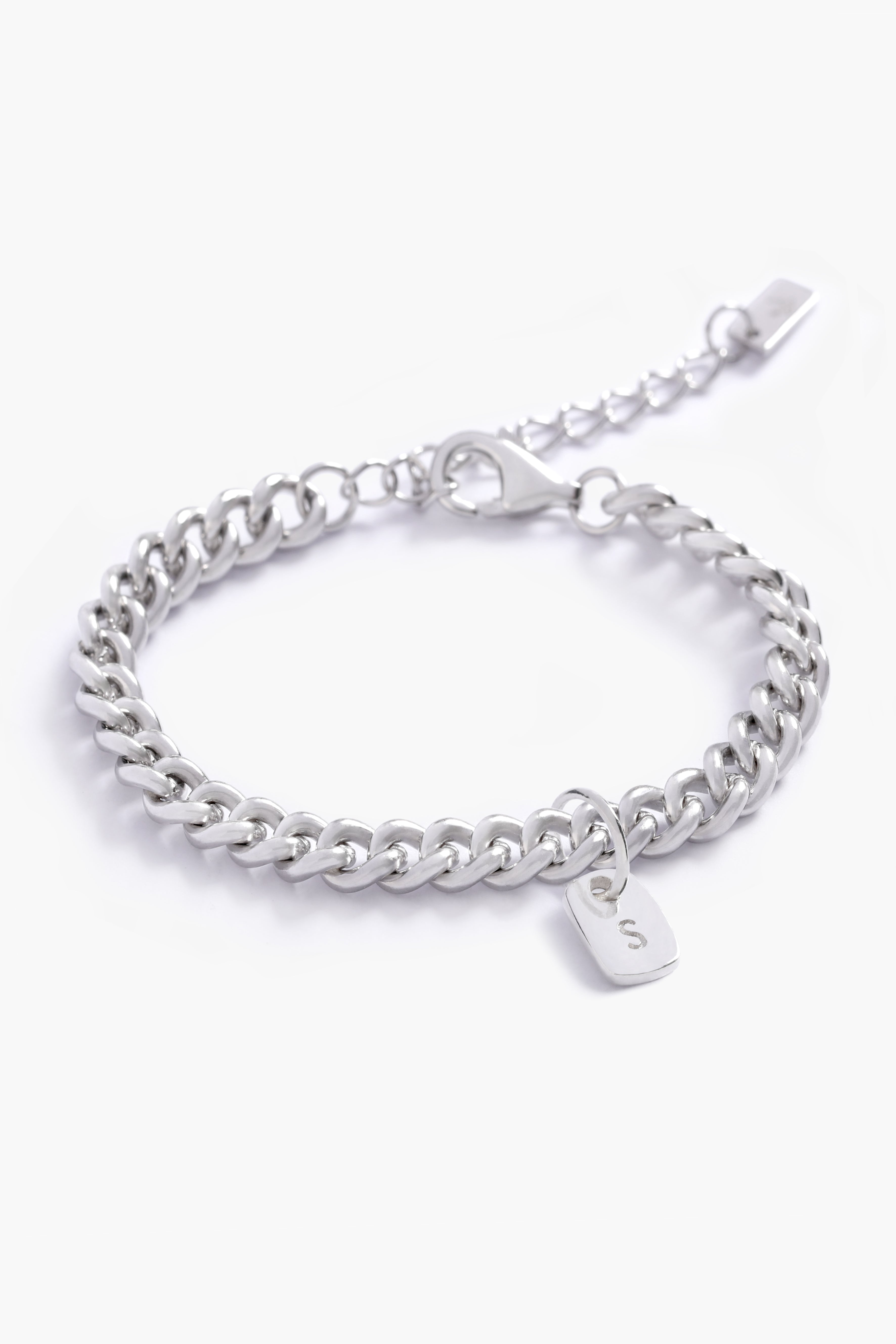 A fine silver bracelet with a rectangular initial pendant, photographed up close to highlight its personalised details and craftsmanship.