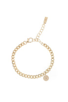 A close-up of a gold anklet with engraved initial pendant, designed as a simple and elegant everyday piece.