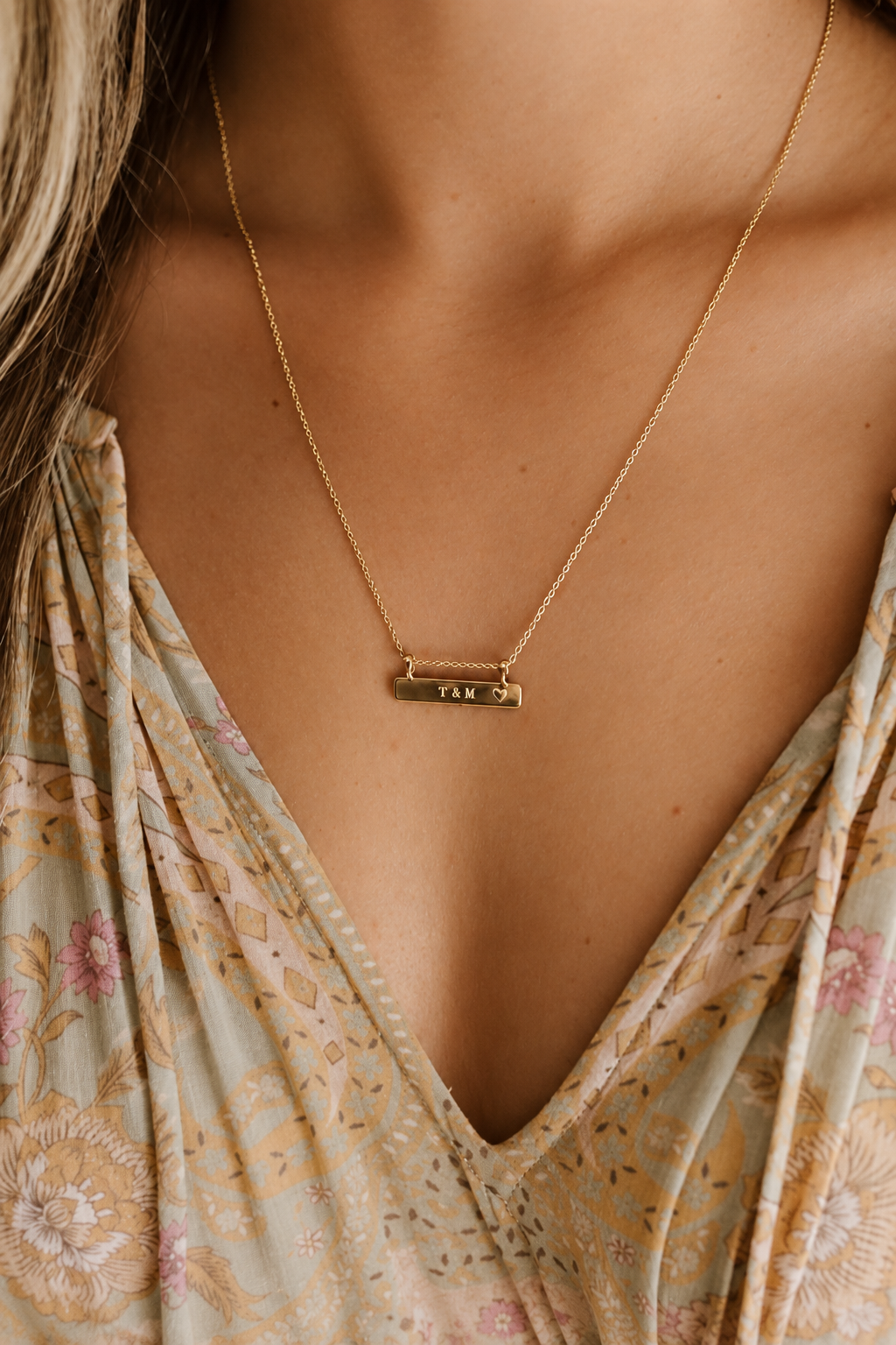 a 50+5cm Darling Bar necklace with initials engraved on it rests elegantly on a woman's neckline
