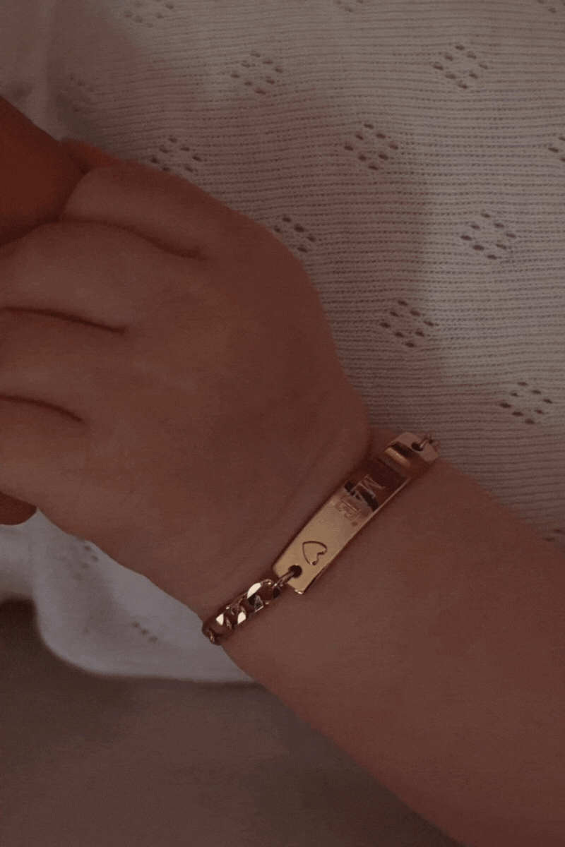New born baby wearing darling bracelet in gold by Bluebird Jewellery.