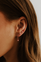 Rose gold Darling Earrings with pink hearts stacked on ear with dangle style stack. 