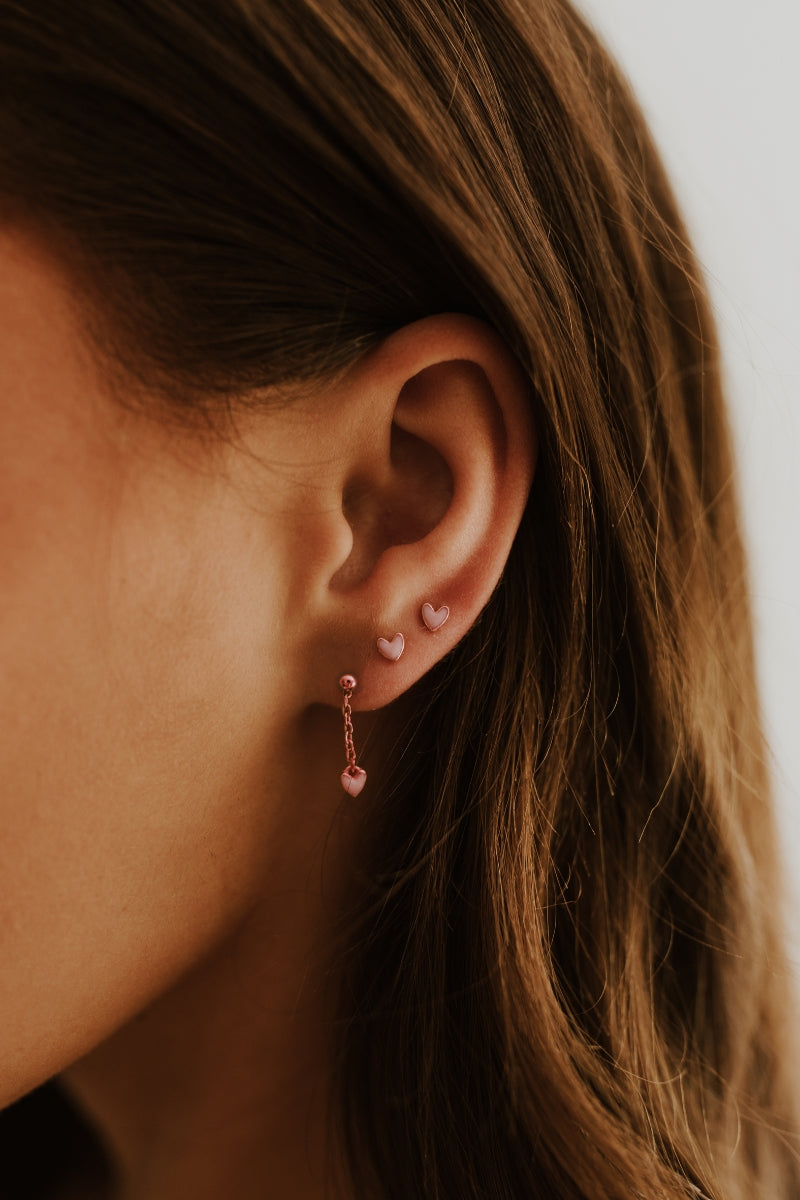 Rose gold Darling Earrings with pink hearts stacked on ear with dangle style stack. 