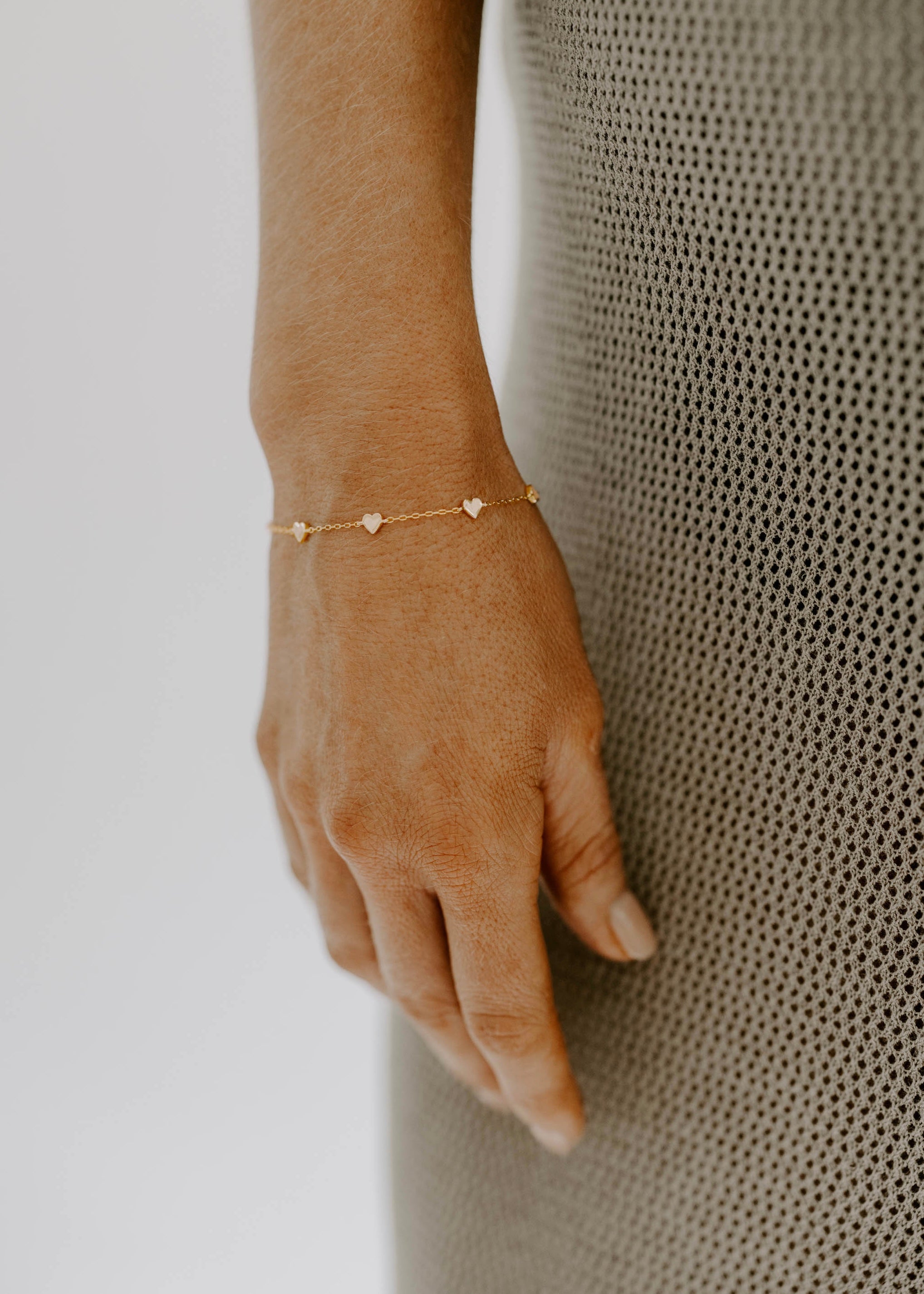 The Darling Heart Bracelet in gold by Bluebird Jewellery, featuring five petite hearts along a delicate chain, crafted as an elegant and timeless piece.