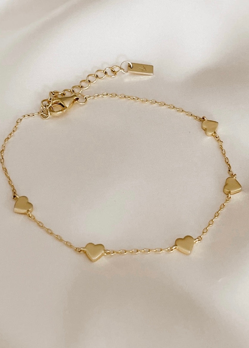 An elegant Darling Heart Bracelet from Bluebird Jewellery, designed with five small hearts in a fine chain, perfect for layering with your Bluebird Co collection.