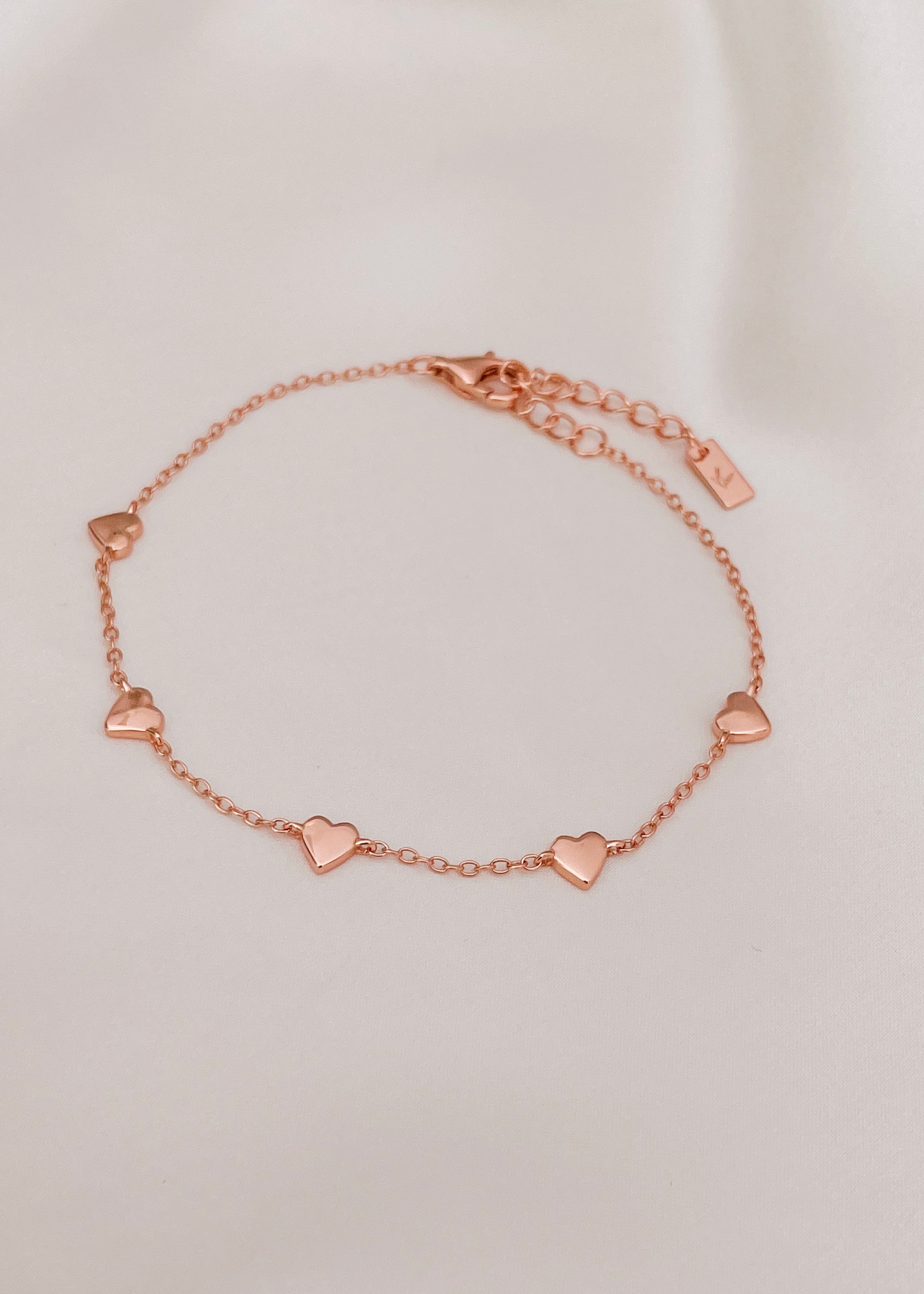 The Bluebird Jewellery Darling Heart Bracelet, featuring five delicate heart motifs in a fine chain, designed as a classic piece for everyday elegance.