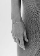 A woman wearing a Darling Heart Bracelet in Silver by Bluebird Jewellery, crafted with five petite hearts for a sweet and timeless look, perfect alongside your Bluebird Co collection.