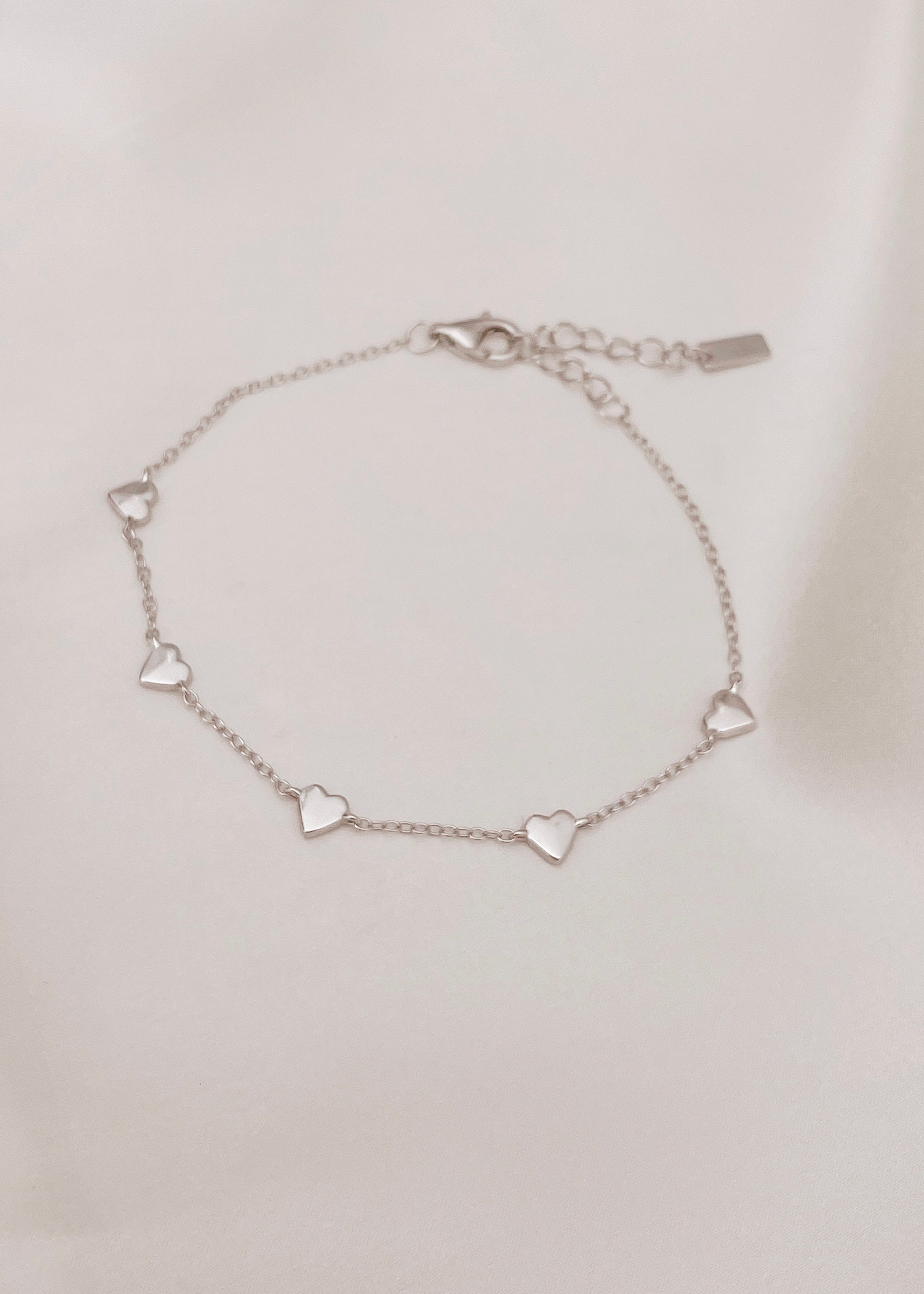 An elegant Darling Heart Bracelet from Bluebird Jewellery, designed with five small hearts in a fine chain, perfect for layering with your Bluebird Co collection.