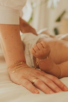 A detailed photo showing matching Posie Bracelets on a mother and baby’s wrists, crafted as sentimental personalised jewellery pieces.