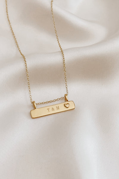 A close up look at the Darling Bar Necklace in gold with personalised engraving of special initials.