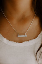 The Darling Bar Necklace is worn by a 9 year old girl.  It is the child size necklace and it sits beautifully above the neckline of her singlet top.