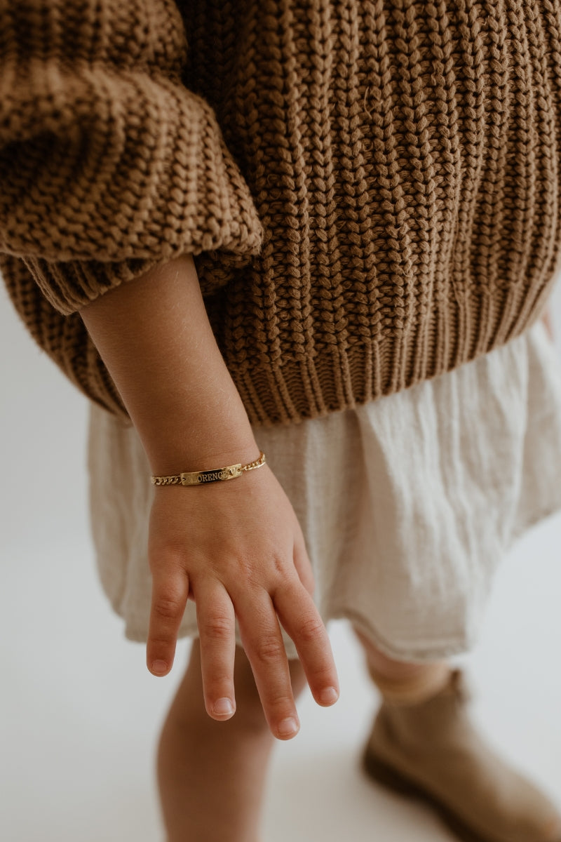 A child sized Darling Bracelet in Gold Vermeil is worn by a 5 year old girl.  The personalised ID Bracelet has been engraved with her name and sits elegantly on her wrist. 