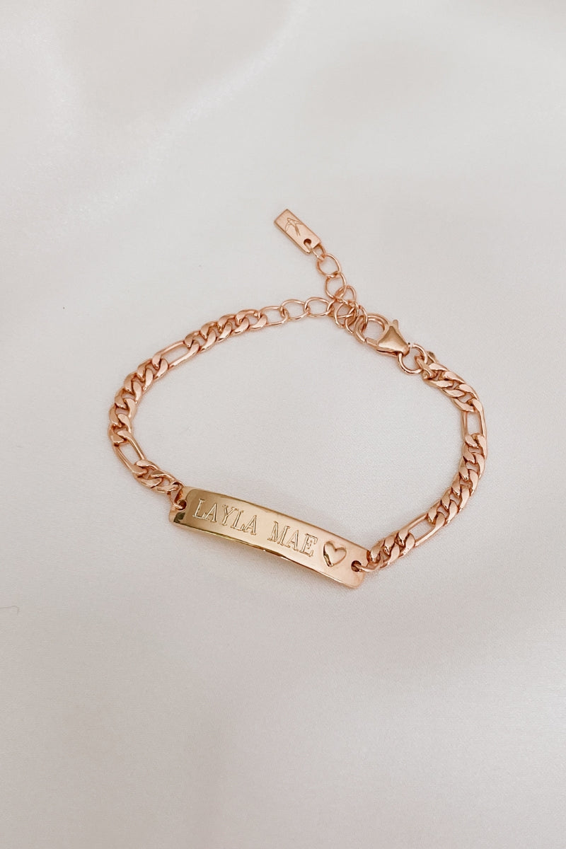 A Darling Bracelet in rose gold has personalised engraving of a child's name on the front of the ID bracelet.  This is a meaningful gift for a child with a small heart at the end of the engravable bar pendant on the bracelet.