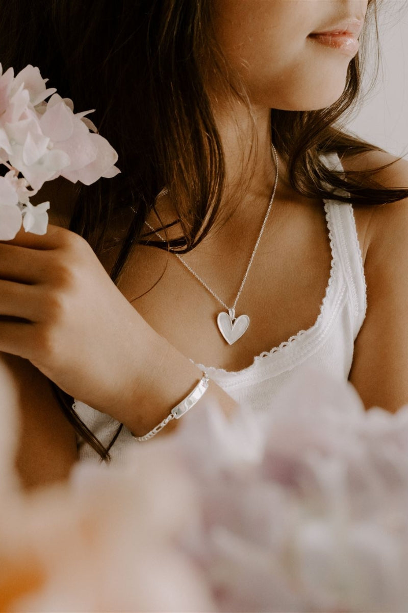 A young girl is wearing the Darling Necklace in the 35+5cm length and it is shown close up.  The girls is also wearing a matching Pink Darling Bracelet in child length.