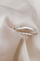 the inside of a pinky ring with the engraving of initials is shown.