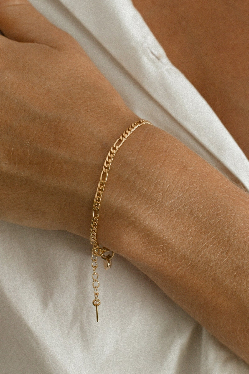 A close-up of the Figaro Bracelet by Bluebird Jewellery, a subtle and elegant gold chain bracelet available in baby, child, and adult lengths.